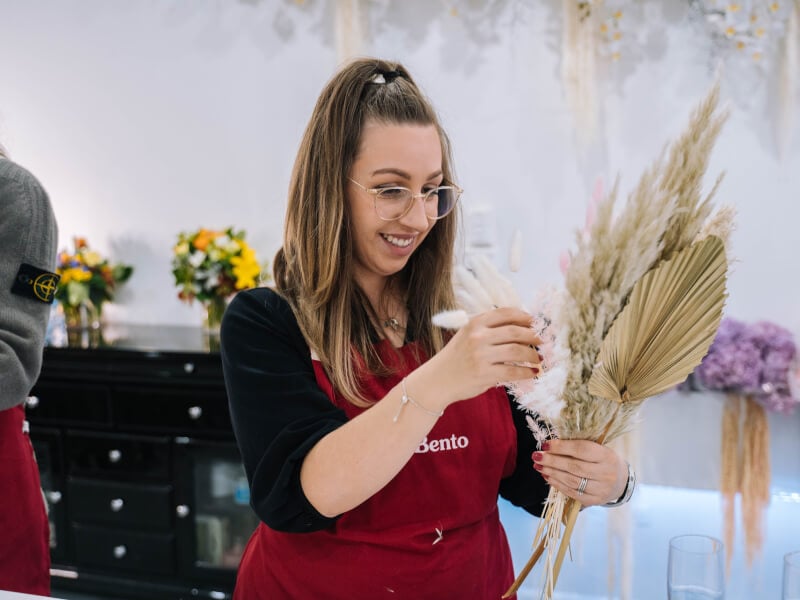 A woman working with dried flowers at the wreath making workshop she was gifted